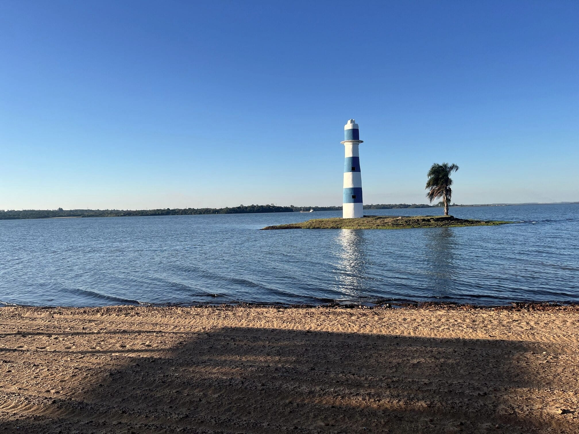 Isla natural con faro de Paraqvaria vista desde la playa