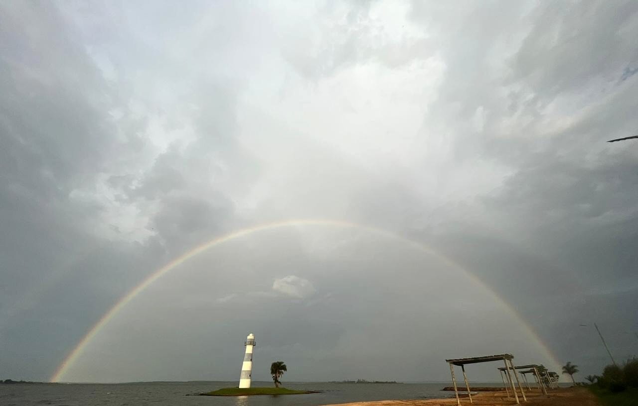 Arcoíris sobre el lago y la isla con faro de Paraqvaria