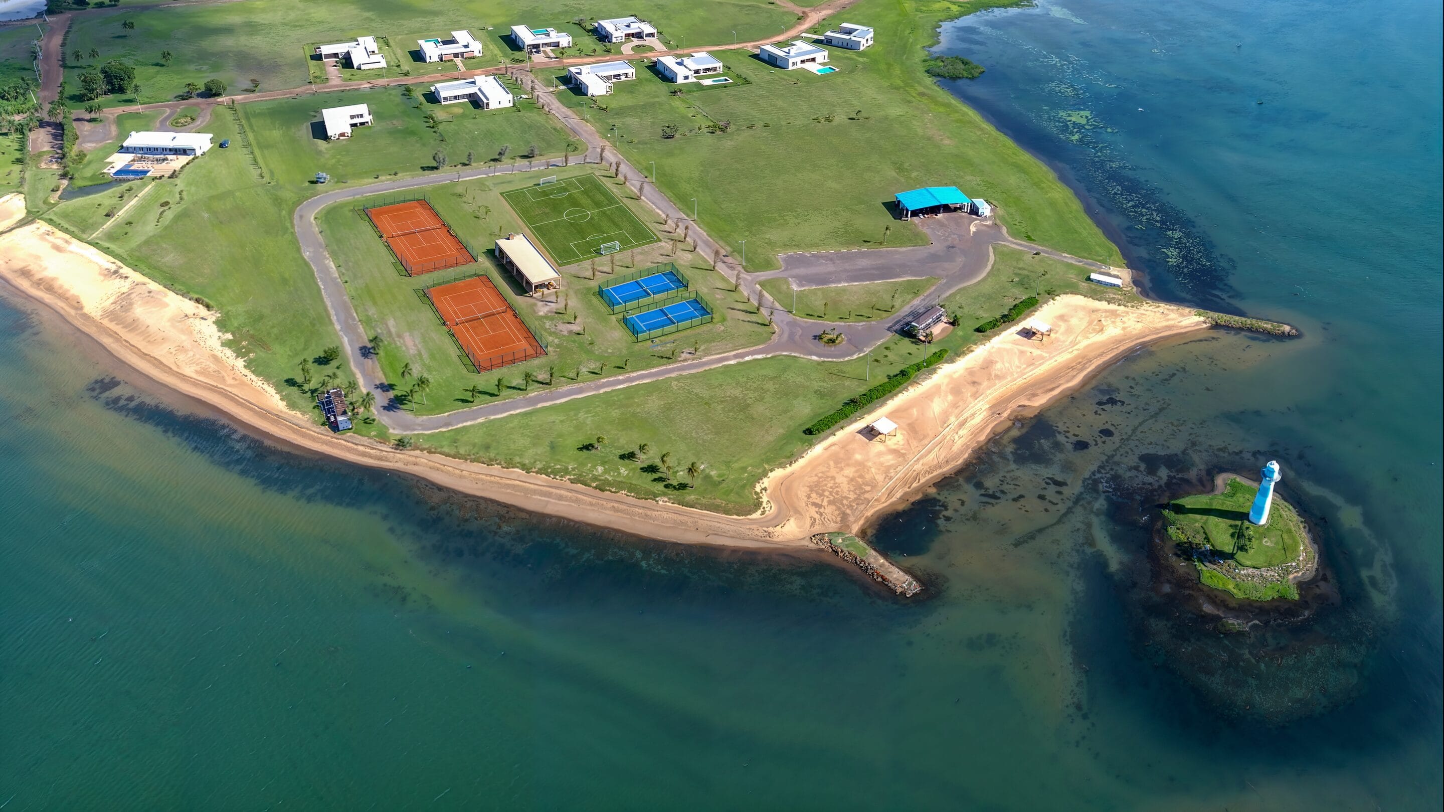Vista aérea de Paraqvaria sobre el Lago Yacyretá, con la costa, las canchas y la isla con faro